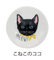 Round white object with a black cat illustration and 'MEOW!' text on a white background